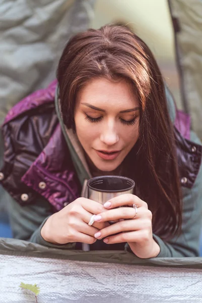 Woman in tent holding metallic cup — Stock Photo