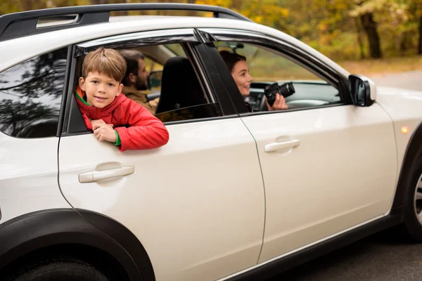 Sonriente chico mirando por la ventana del coche - foto de stock