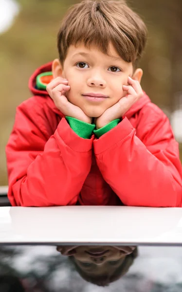 Lindo niño de pie en el coche - foto de stock