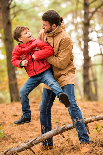 Boy playing with father in forest — Stock Photo