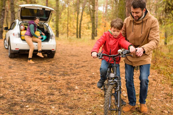 Padre enseñando a su hijo a andar en bicicleta - foto de stock