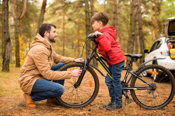 Father teaching son to ride bicycle — Stock Photo