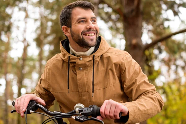Улыбающийся мужчина сидит на велосипеде — стоковое фото