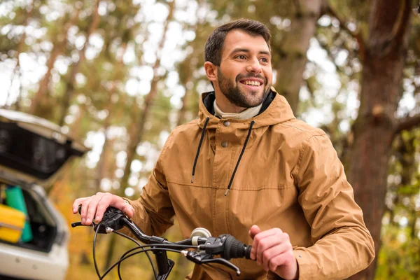 Hombre sonriente sentado en bicicleta - foto de stock