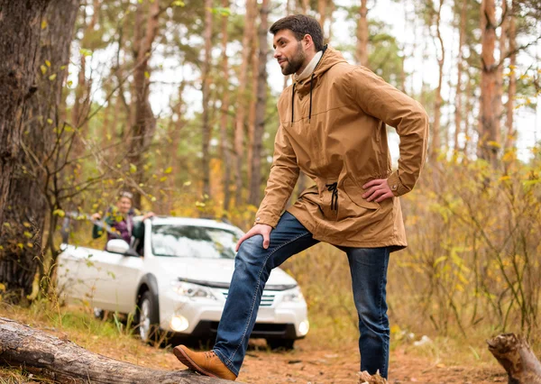 Mann steht auf trockenem Baumstamm im Wald — Stockfoto