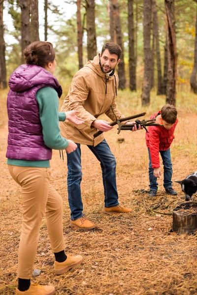 Familia feliz recogiendo leña - foto de stock