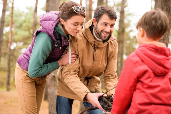 Happy family collecting firewood — Stock Photo