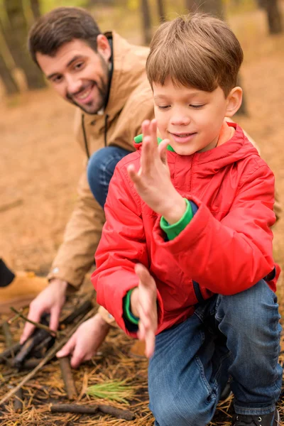 Father and son kindle bonfire — Stock Photo