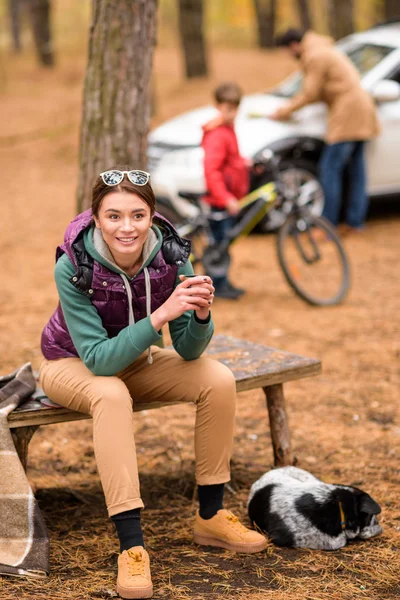 Усміхнена жінка з гарячим напоєм у лісі — стокове фото