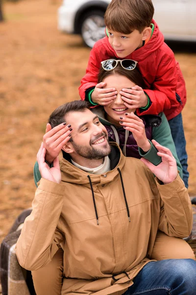 Familia feliz jugando en el bosque de otoño - foto de stock