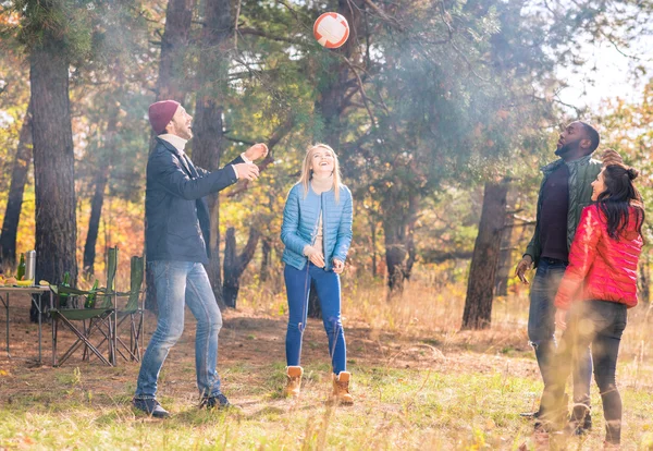 Amigos felices jugando con la pelota en el parque - foto de stock