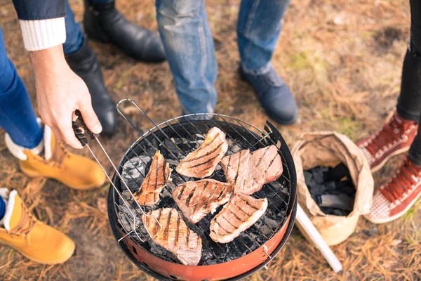 Menschen kochen Fleisch auf Holzkohlegrill — Stock Photo