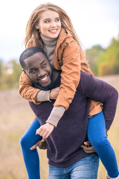Happy young couple piggybacking — Stock Photo