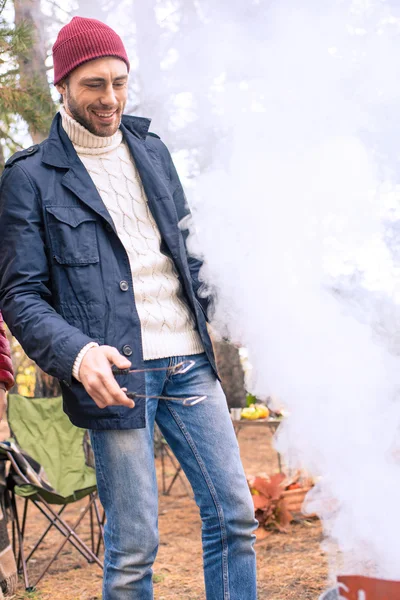 Hombre sonriente preparando barbacoa - foto de stock