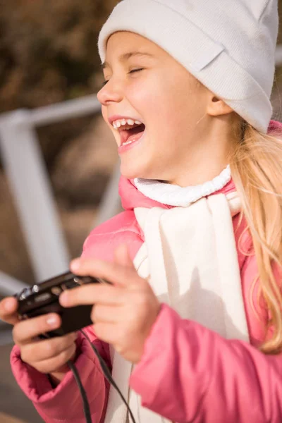 Ragazza sorridente che tiene macchina fotografica — Foto stock