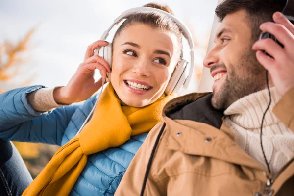 Jovem casal alegre em fones de ouvido — Fotografia de Stock