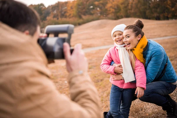 Hombre fotografiando feliz madre e hija - foto de stock