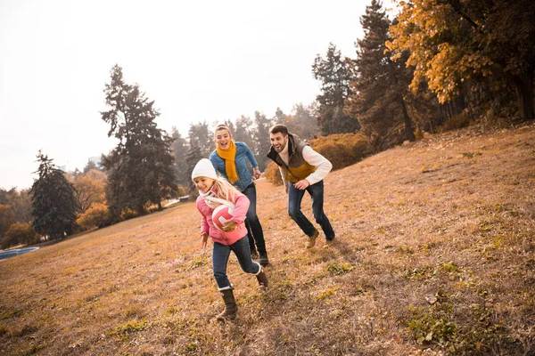 Familia feliz jugando en el parque - foto de stock