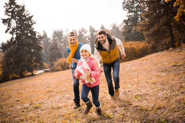 Familia feliz jugando en el parque - foto de stock