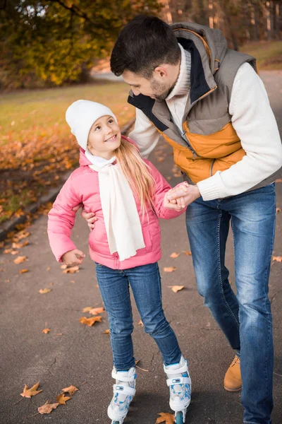 Pai ensinando filha a patinar — Fotografia de Stock