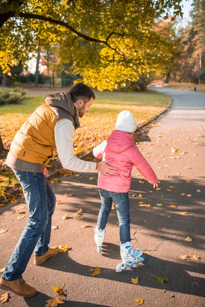 Padre insegnare figlia a pattinare a rotelle — Foto stock