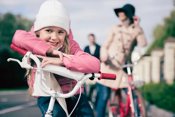 Linda niña sentada en bicicleta - foto de stock