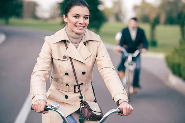 Красива усміхнена жінка їде на велосипеді — стокове фото