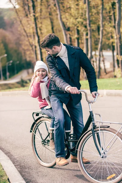 Padre llevando hija en bicicleta - foto de stock