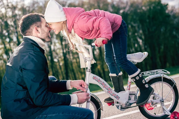 Батько перевірка велосипедів маленька дочка — стокове фото