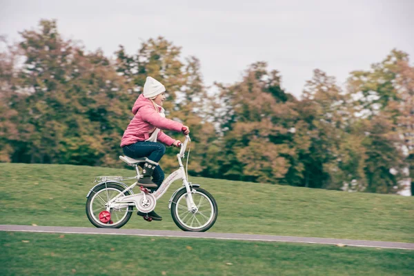 Little girl riding bicycle in park — Stock Photo