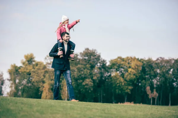 Padre sorridente che porta la figlia sulle spalle — Foto stock