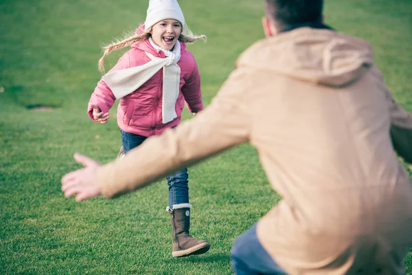 Очаровательная улыбающаяся девушка бежит к отцу — стоковое фото