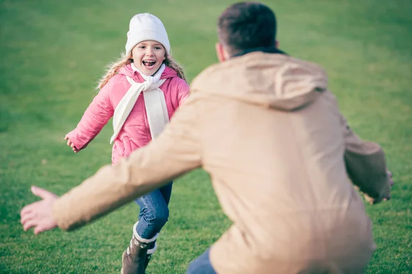 Liebenswertes lächelndes Mädchen läuft zum Vater — Stockfoto