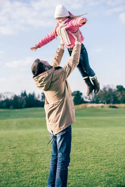 Pai segurando filha e brincando no parque — Fotografia de Stock