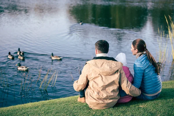 Familia mirando el lago con patos — Stock Photo