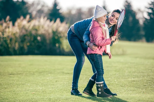 Усміхнена мати з дочкою грає в бадмінтон — стокове фото