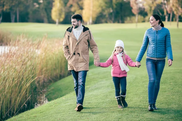 Happy family walking near lake — Stock Photo