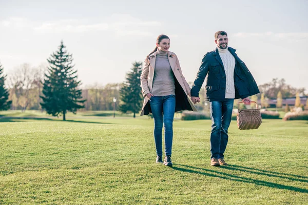 Glückliches Paar spaziert mit Picknickkorb — Stockfoto