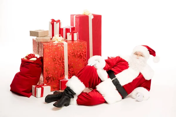 Санта-Клаус возле кучи рождественских подарков — стоковое фото