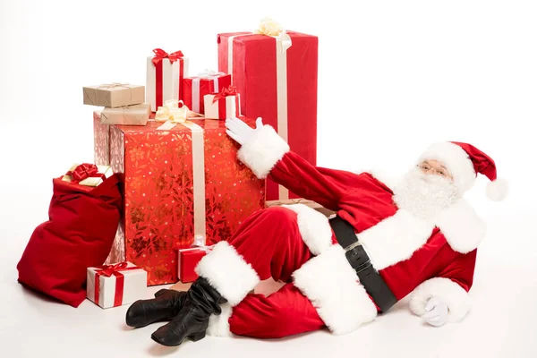 Santa Claus near pile of Christmas gifts — Stock Photo
