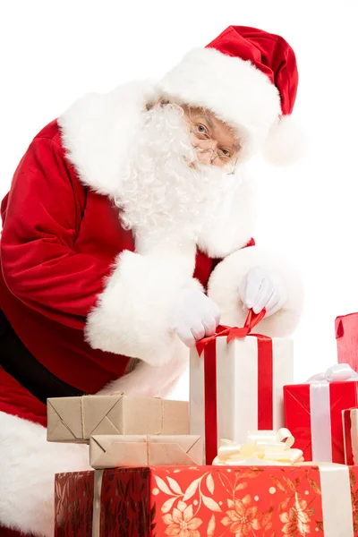 Santa Claus with pile of Christmas gifts — Stock Photo