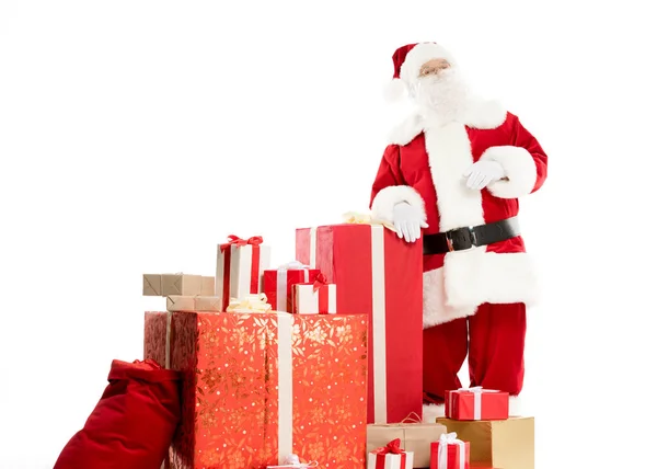 Santa Claus with pile of Christmas gifts — Stock Photo