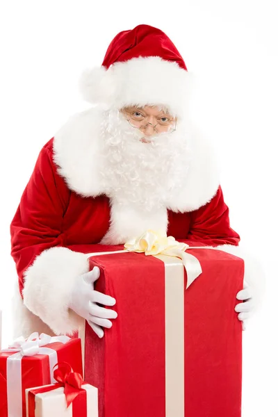 Santa Claus with pile of Christmas gifts — Stock Photo