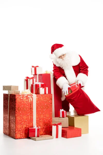 Santa Claus taking out Christmas gifts from sack — Stock Photo