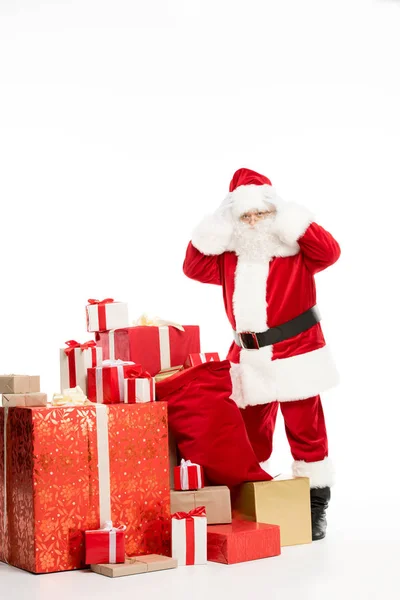 Shocked Santa Claus standing with Christmas gifts — Stock Photo