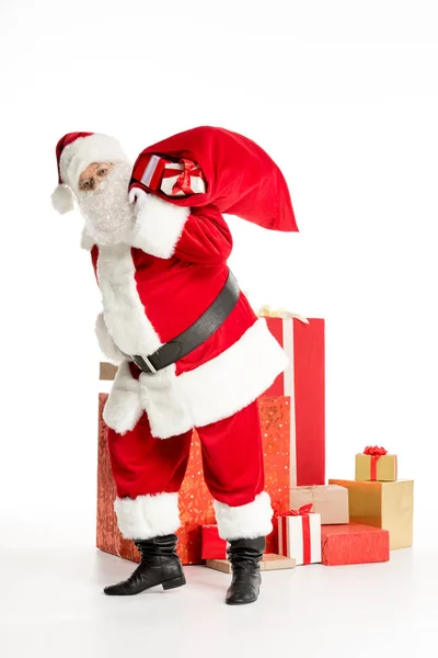 Santa Claus with pile of Christmas gifts — Stock Photo