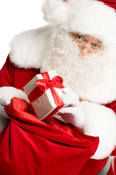 Санта Клаус достает рождественский подарок из мешка — стоковое фото