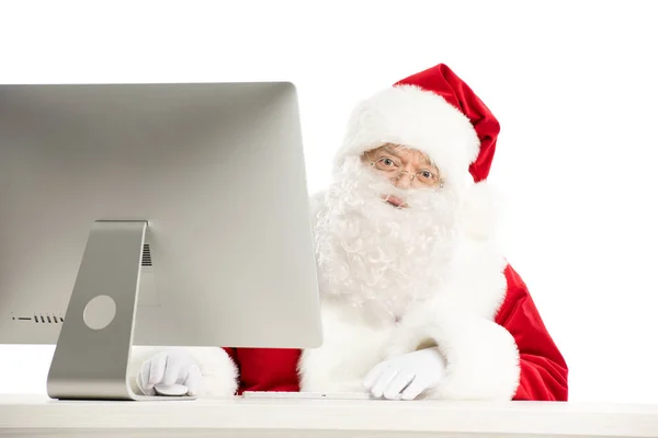 Père Noël assis au bureau avec ordinateur — Photo de stock