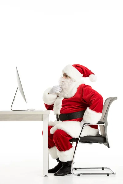Задумчивый Санта Клаус смотрит на компьютер — стоковое фото