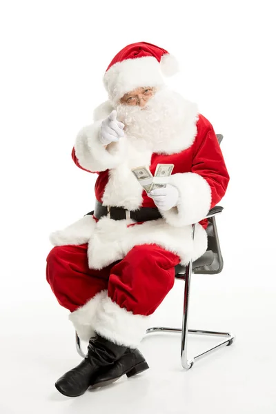Санта-Клаус сидит с долларами в руке — стоковое фото